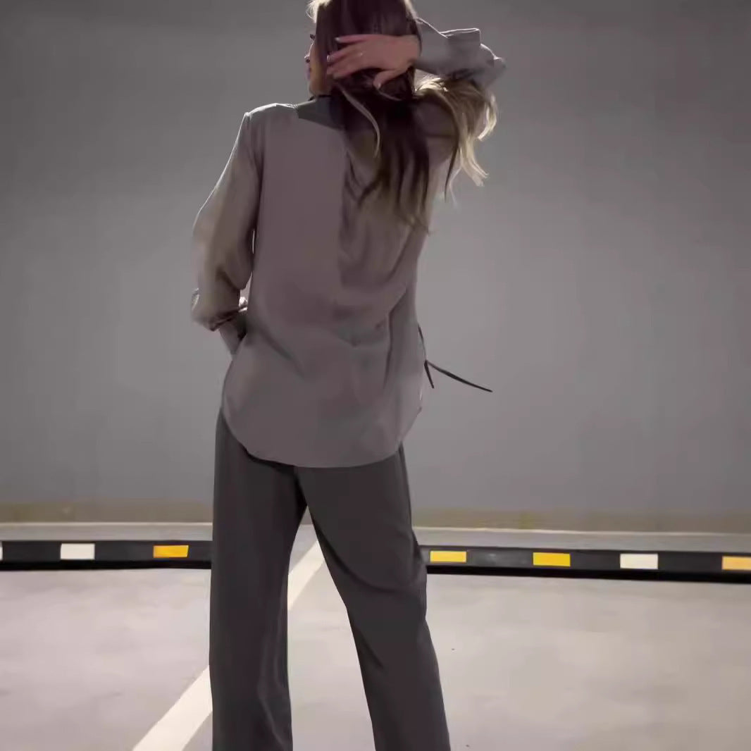 Modern outfit with asymmetrical long-sleeved blouse and wide-legged pants