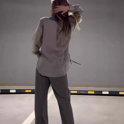 Modern outfit with asymmetrical long-sleeved blouse and wide-legged pants