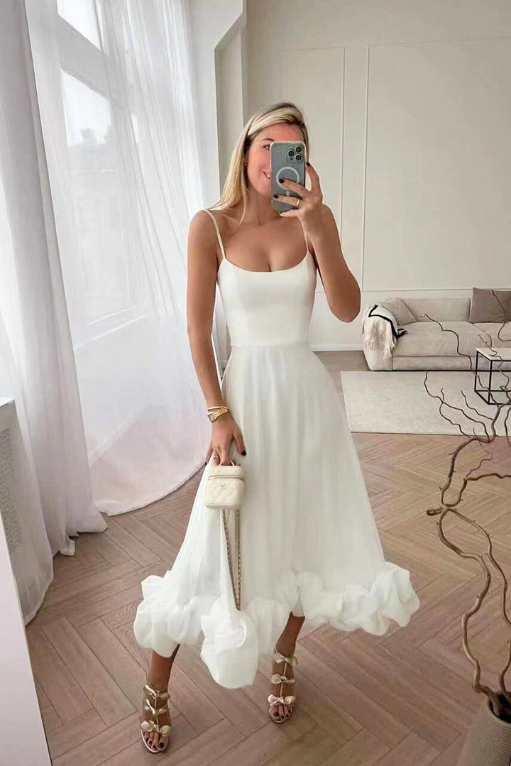 Elegant midi dress with thin straps and a flowing ruffle at the hem