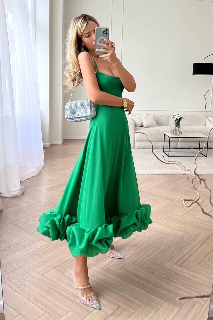 Elegant midi dress with thin straps and a flowing ruffle at the hem