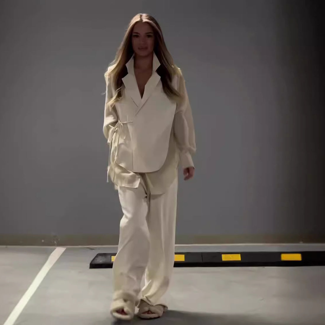 Modern outfit with asymmetrical long-sleeved blouse and wide-legged pants
