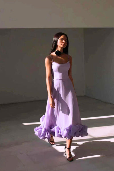 Elegant midi dress with thin straps and a flowing ruffle at the hem