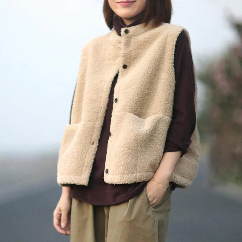 Elegant warm women's vest in nude color with large pockets and buttons