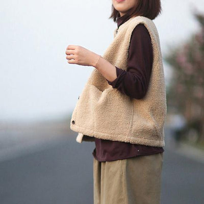 Elegant warm women's vest in nude color with large pockets and buttons