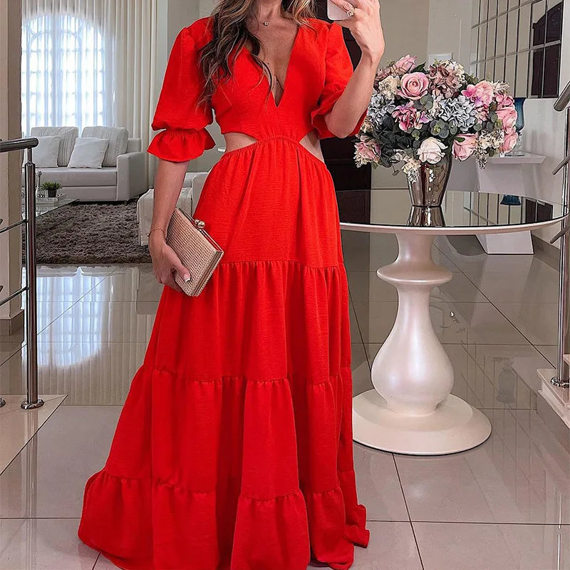 Long summer dress with flared sleeves, a deep neckline, and a cut at the waist