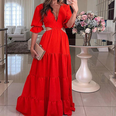 Long summer dress with flared sleeves, a deep neckline, and a cut at the waist