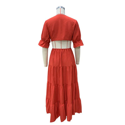 Long summer dress with flared sleeves, a deep neckline, and a cut at the waist
