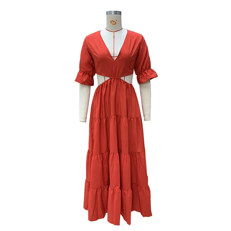 Long summer dress with flared sleeves, a deep neckline, and a cut at the waist