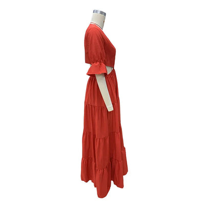 Long summer dress with flared sleeves, a deep neckline, and a cut at the waist