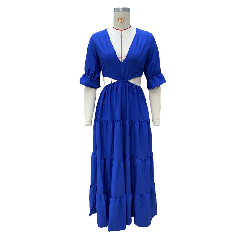 Long summer dress with flared sleeves, a deep neckline, and a cut at the waist