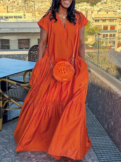 Long flowing dress with V-neckline, pleats and side pockets